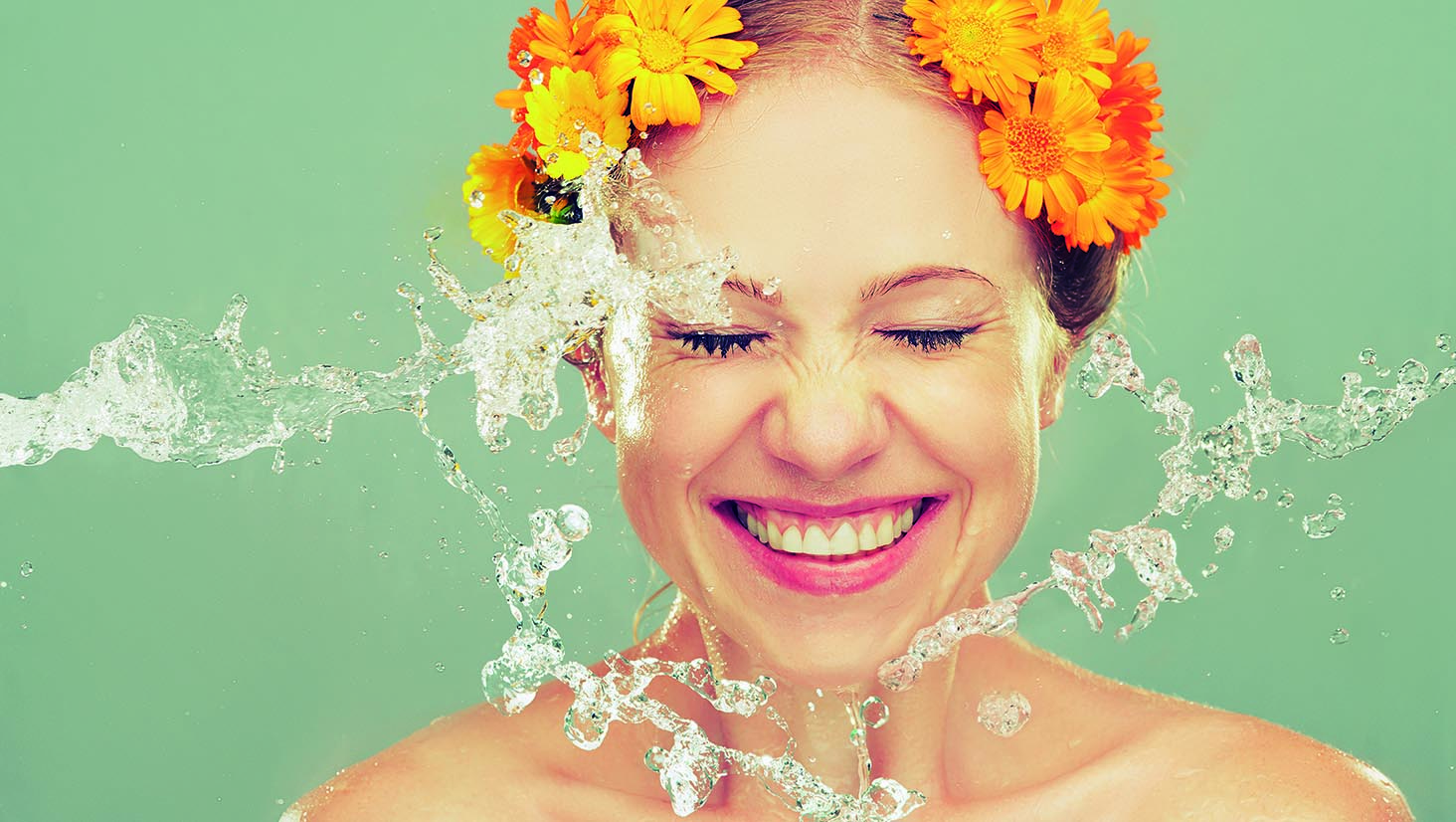 beauty laughing girl with splashes of water and yellow flowers